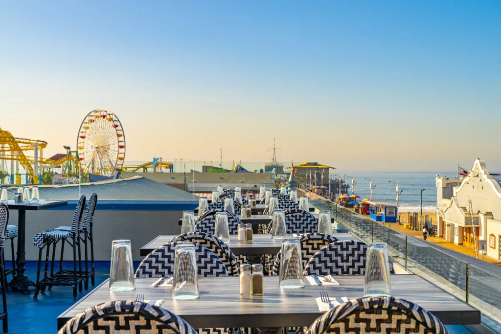 Rooftop dining with ocean and Santa Monica Pier views, including Ferris wheel, at Seaside on the Pier.